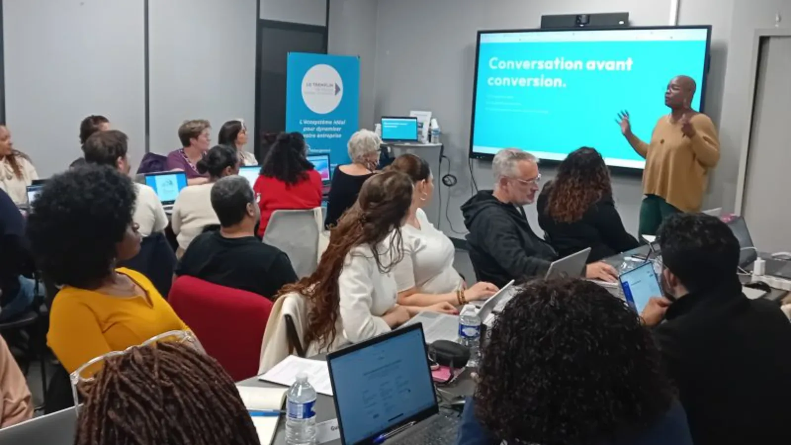 Atelier prospection du 5 mai 2026 au Tremplin Val Parisis : Jennifer Anselme anime devant une vingtaine d'entrepreneurs, slide projetée 'Conversation avant conversion'.